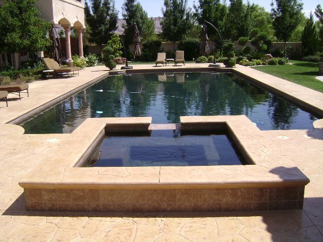 A large swimming pool with a hot tub in the middle