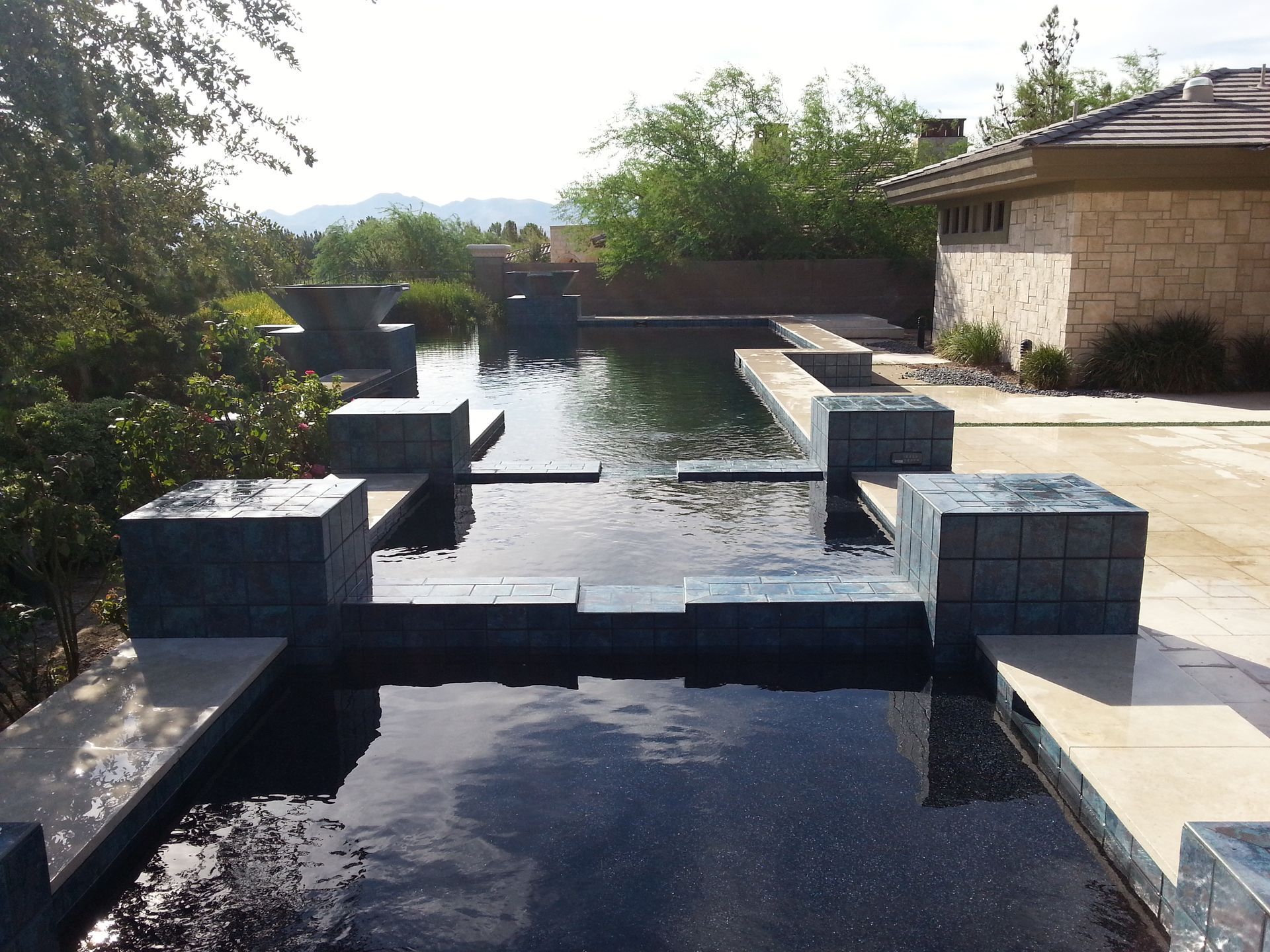 A large swimming pool with a house in the background