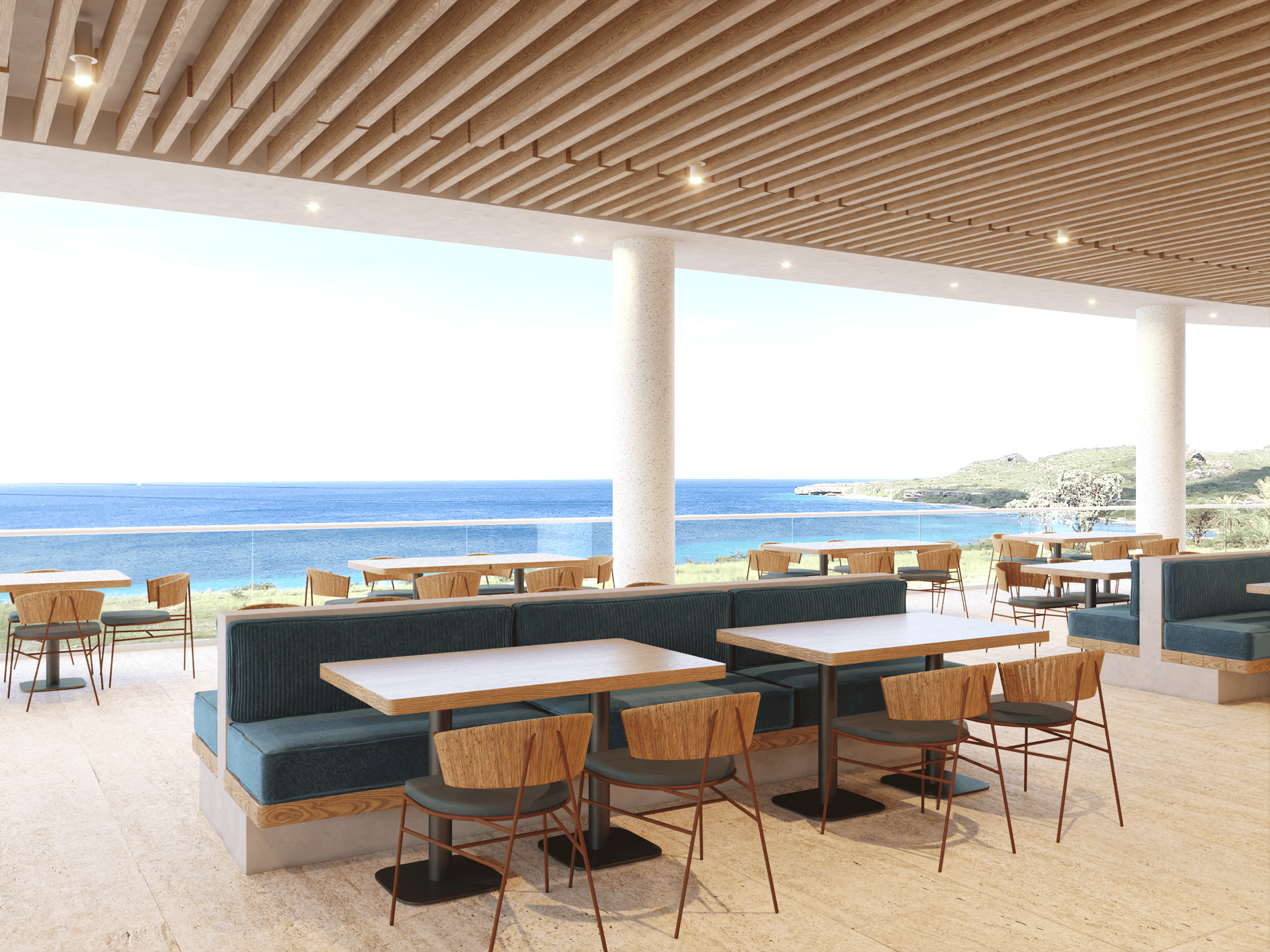 Restaurant patio with ocean view; teal banquette seating, wooden tables and chairs.