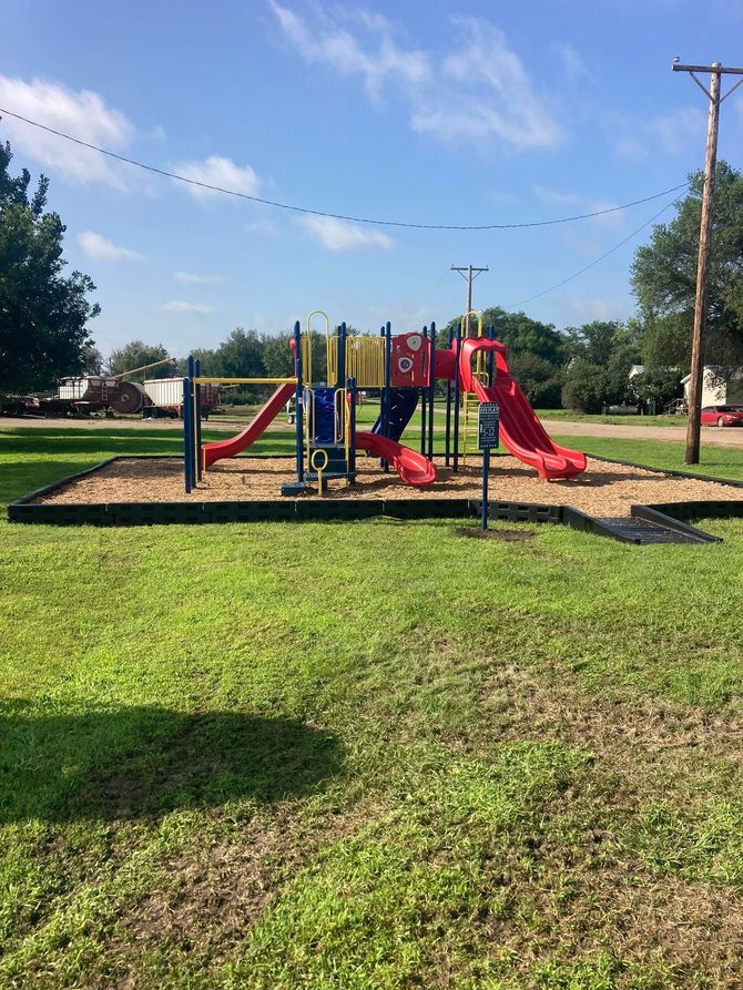 Colorful playground with slides and climbing structures on a sunny grassy field