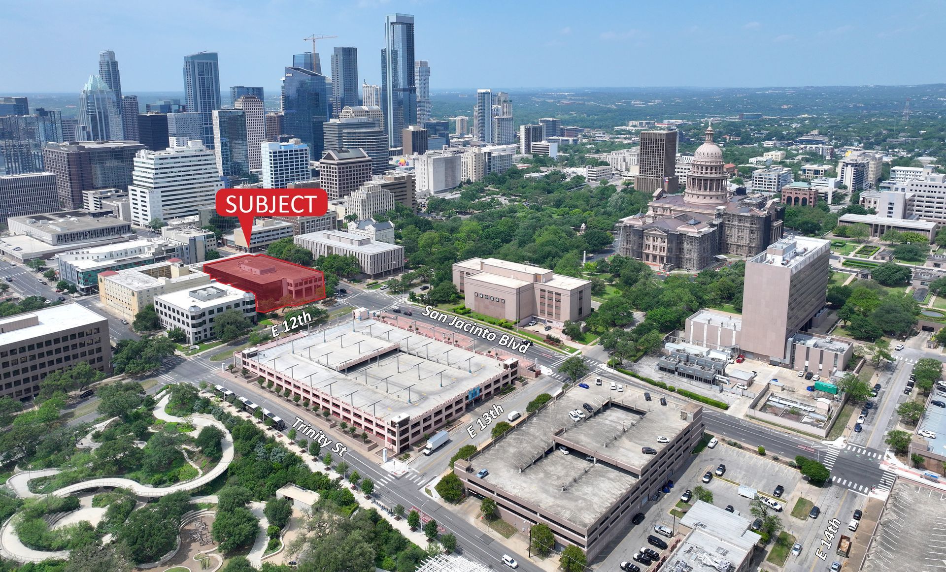 An aerial view of a city with a red arrow pointing to a building.