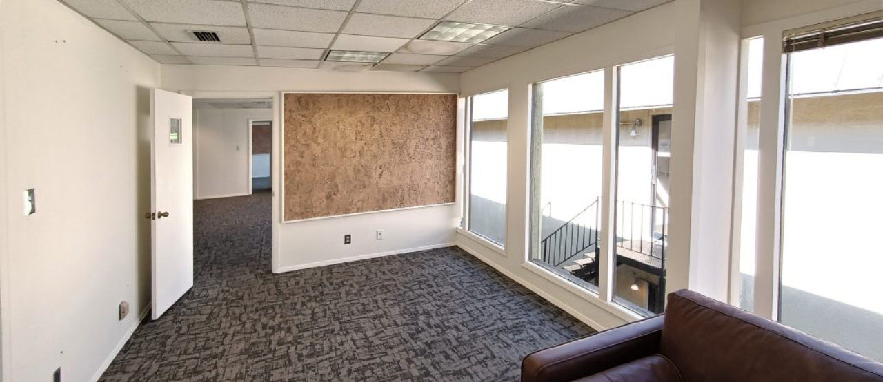 an empty room with a couch and a lot of windows