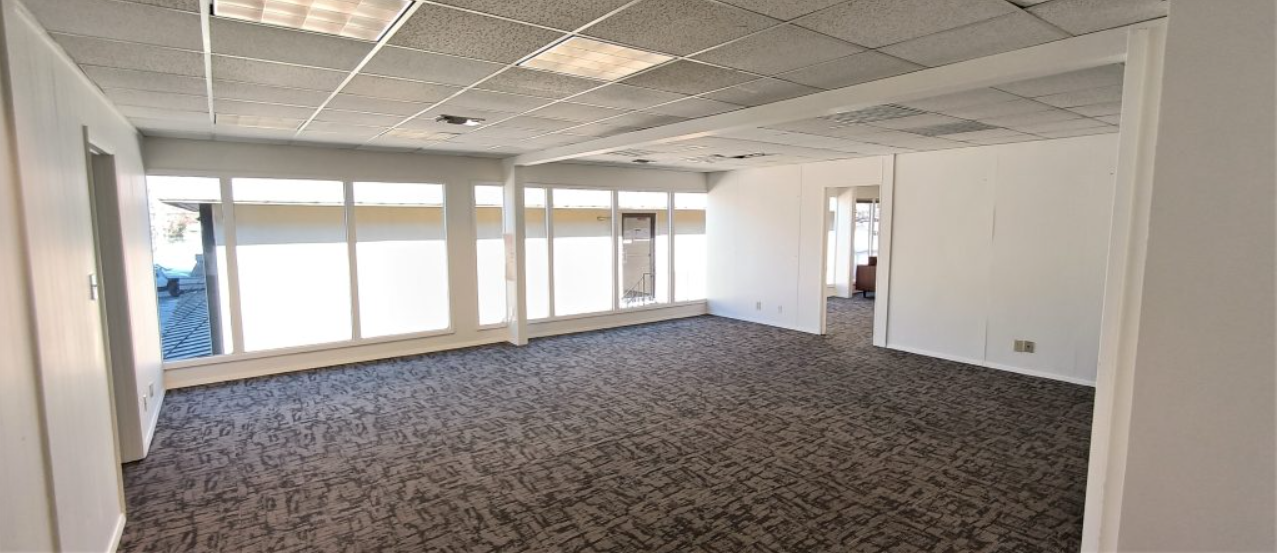 a large empty room with a lot of windows and carpet .