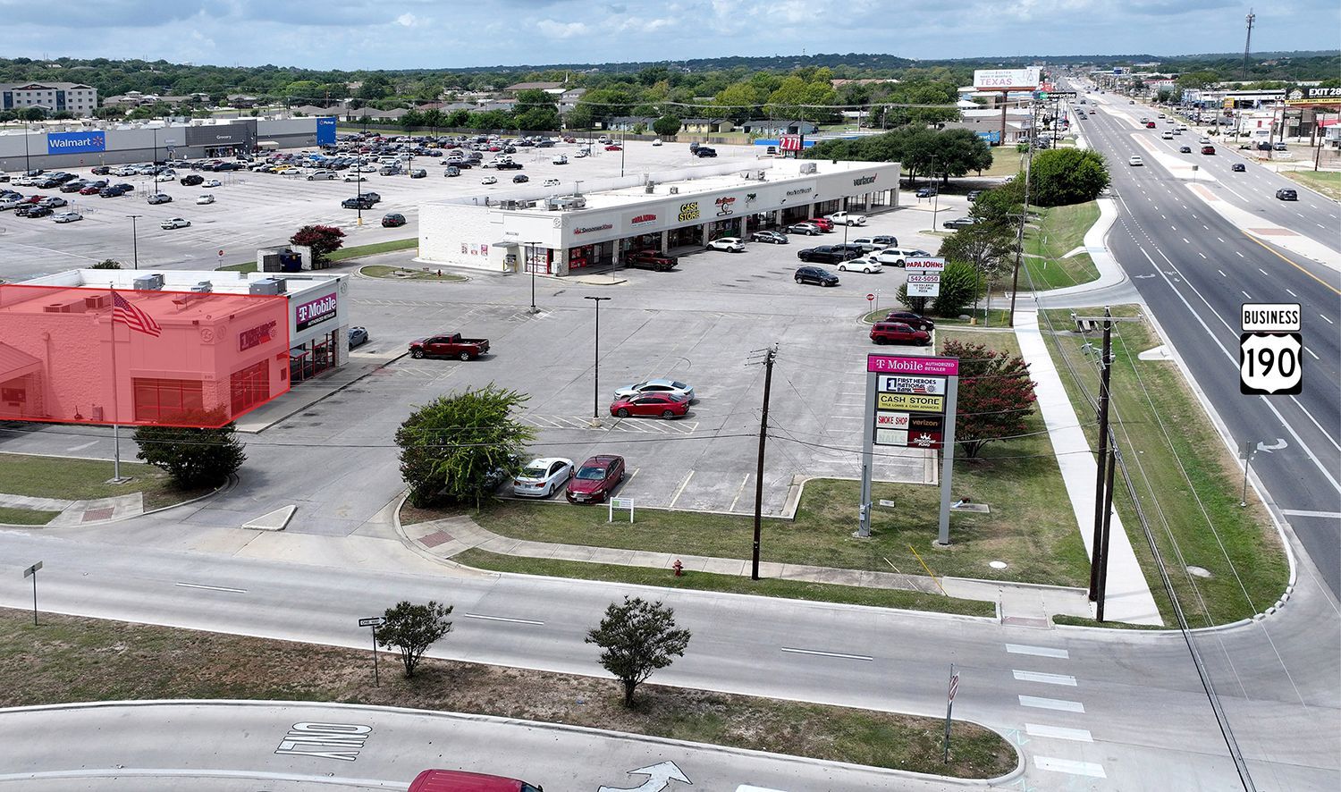 Aerial view of a Walmart parking lot and roadway with a Texas Highway 190 sign.