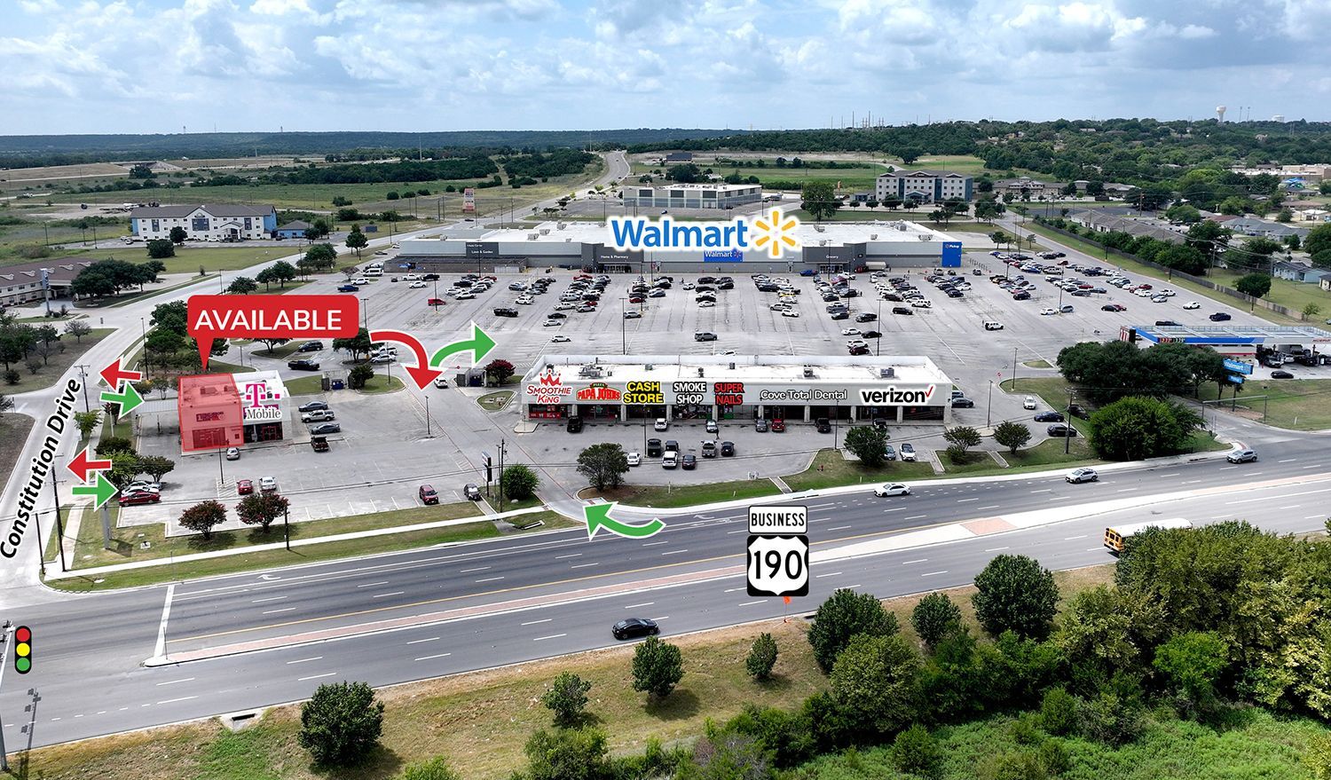 Aerial view of a Walmart shopping center with a parking lot, nearby road, and surrounding greenery