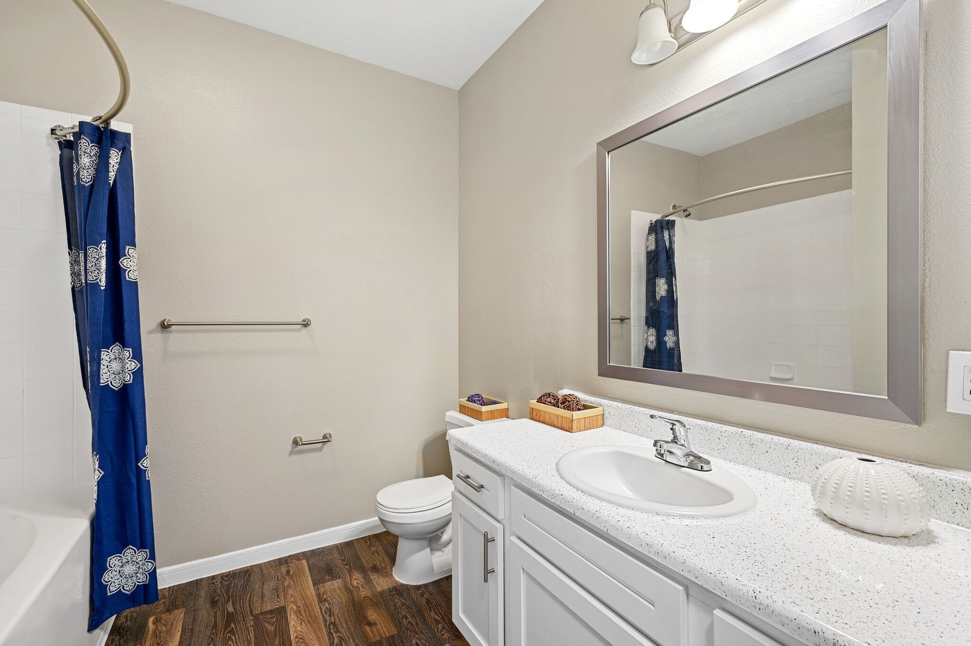 A bathroom with a sink , toilet , shower and mirror.