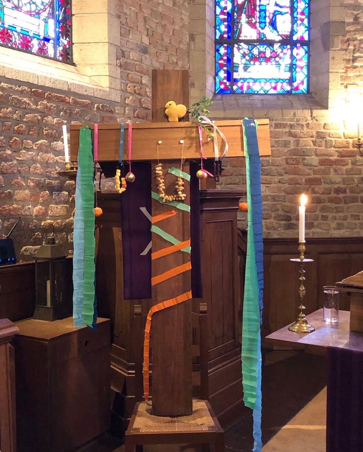 Groot houten kruis versierd met Palmpasen door de Kindernevendienst