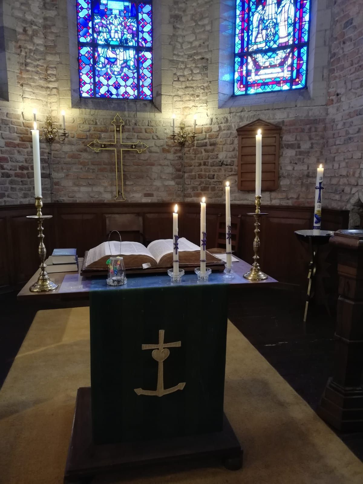 brandende doopkaarsen op liturgietafel