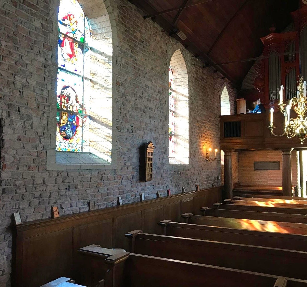 Interieur met glas in lood ramen en zicht op het orgel