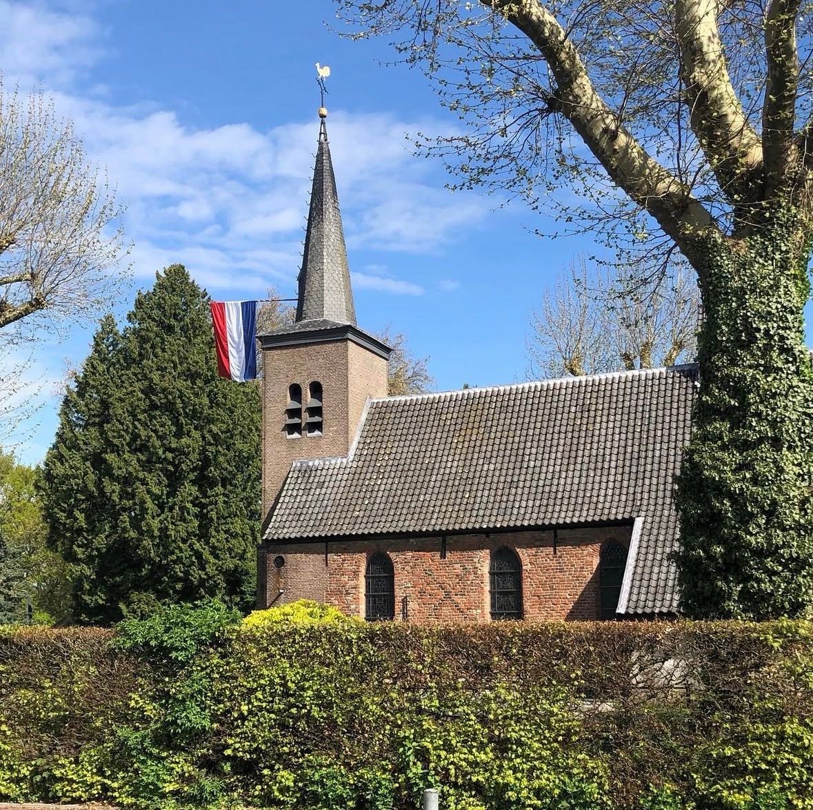 Kerk met uit de toren de Nederlandse vlag met Koningsdag