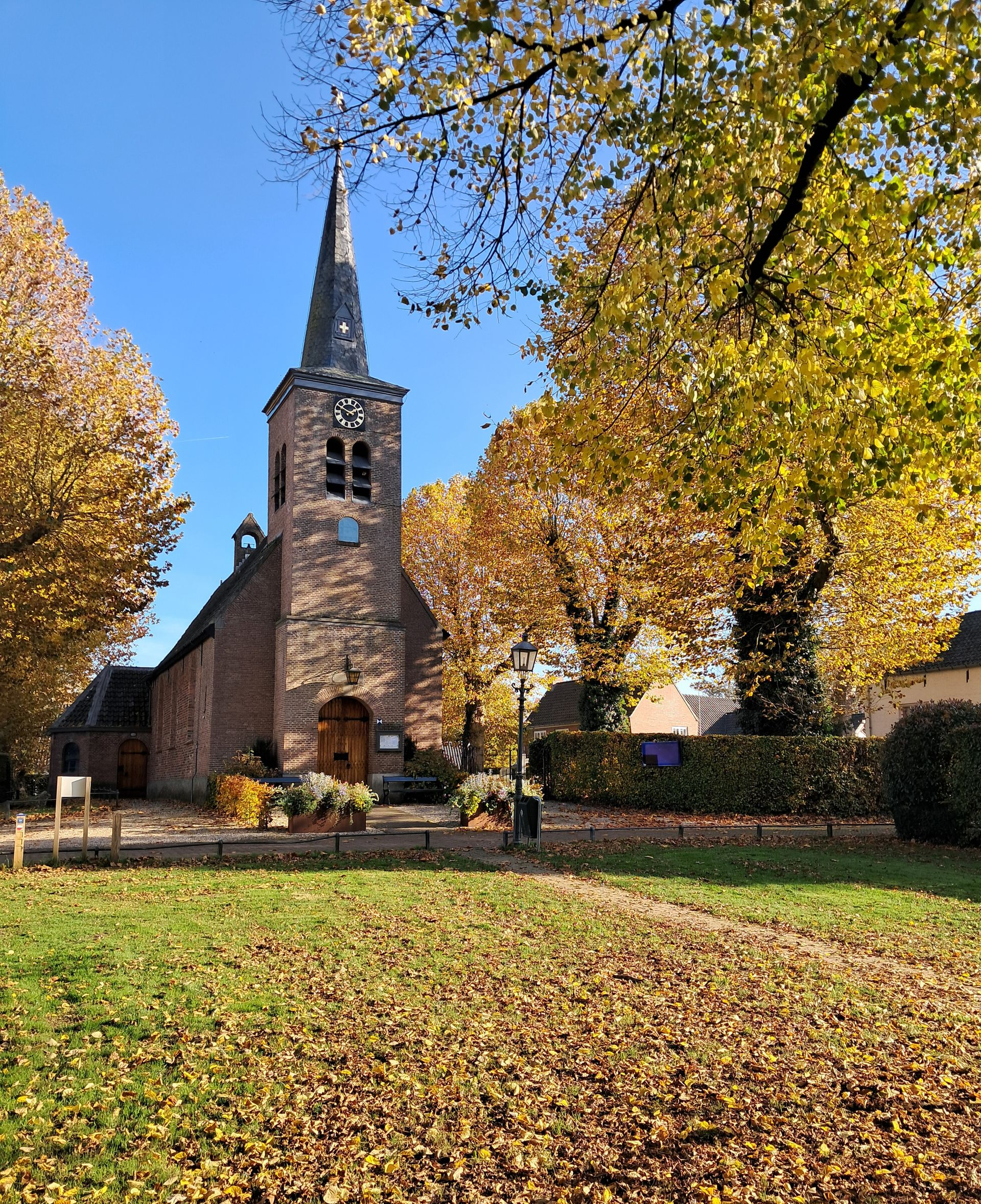 Voorzijde kerk met gekleurd blad in de herfst