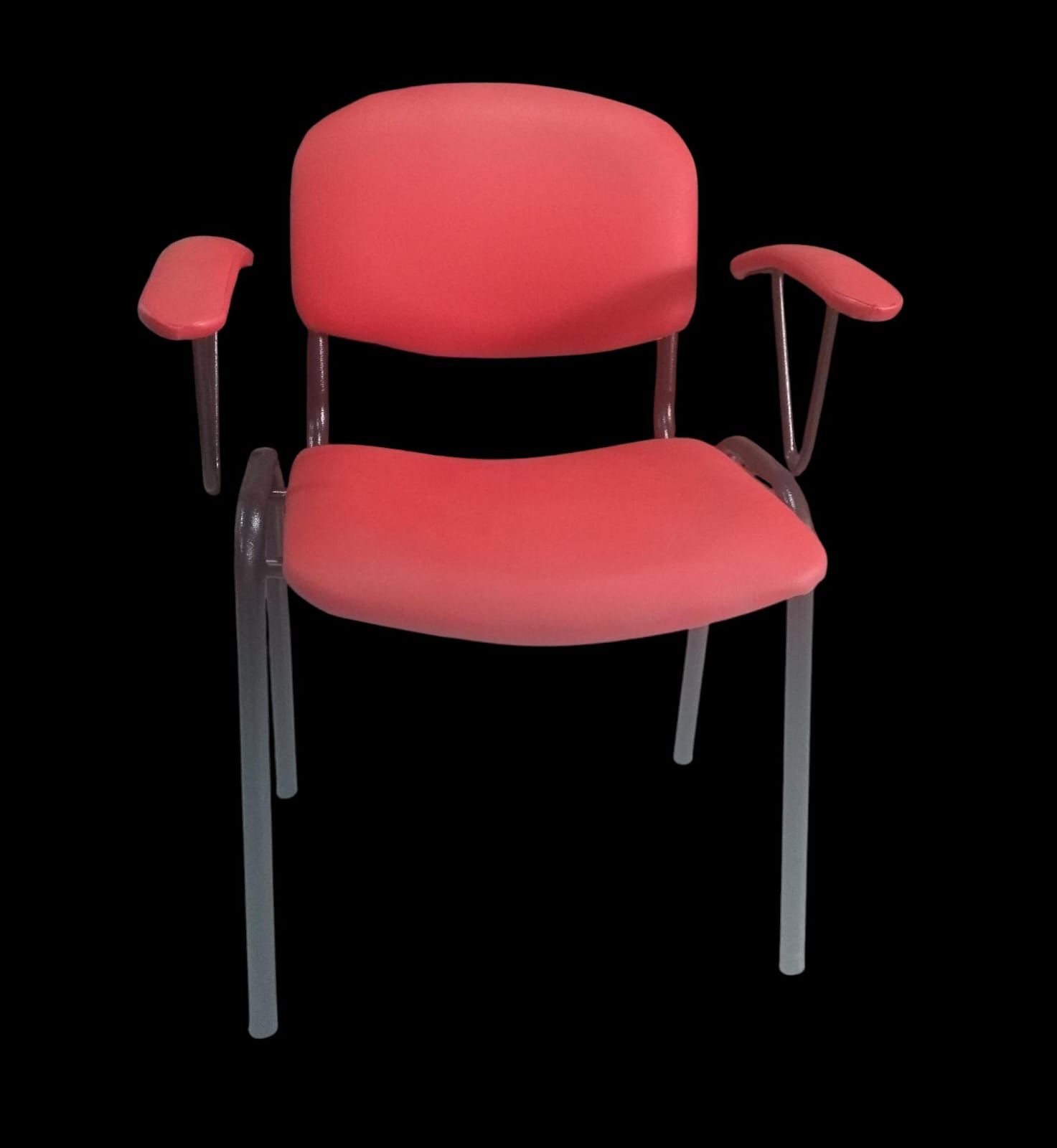 Silla tapizada en rojo con patas y reposabrazos de metal gris sobre fondo negro.