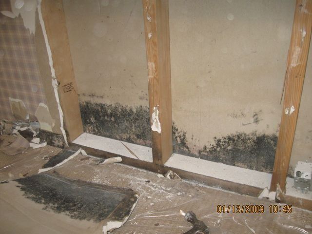 Attic crawlspace with plywood walls, ceiling insulation, and yellow and white pipes running through it