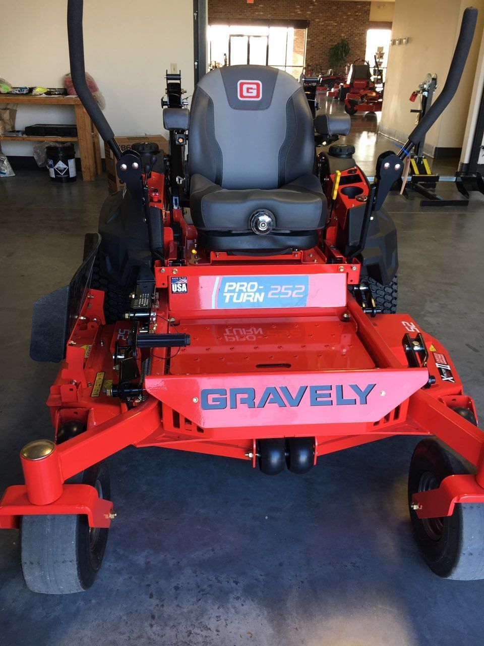 A red Gravely Pro-Turn 252 zero-turn mower positioned in a showroom with a gray seat and black steering levers.