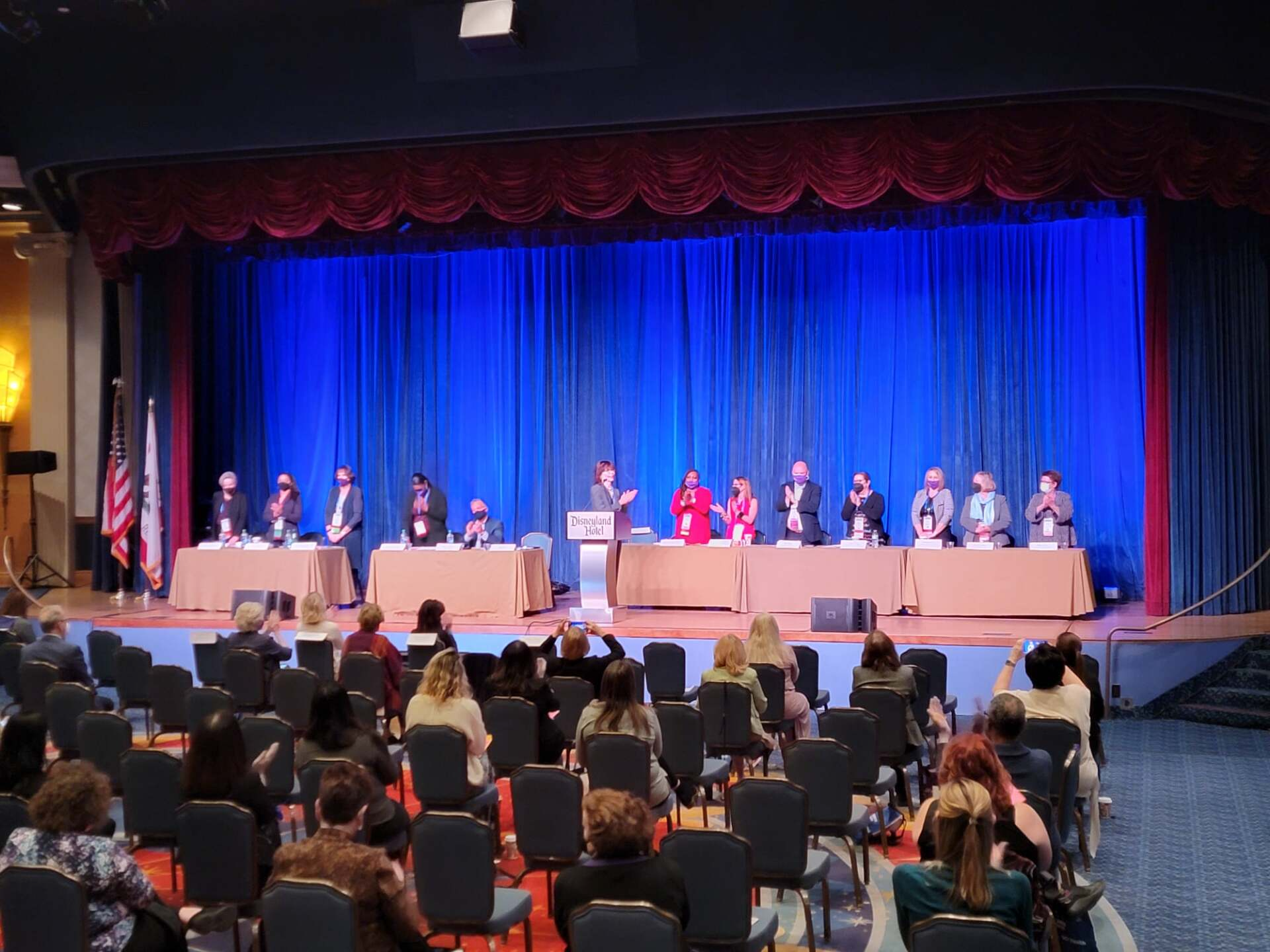A group of people are sitting in chairs in front of a stage.