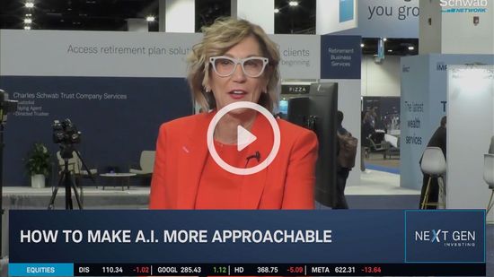 Woman in orange blazer speaking on stage, with “How to make AI more approachable” banner and play icon overlay