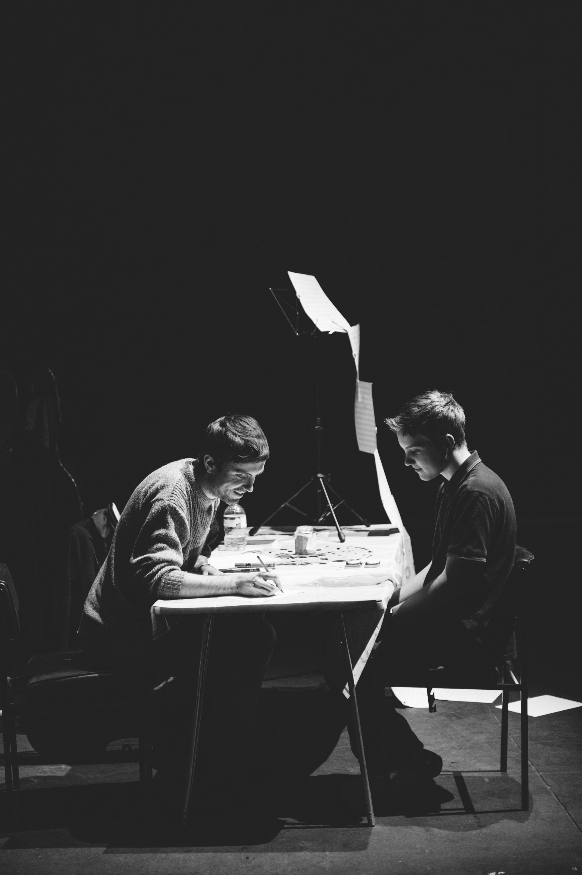 A black and white photo of two men sitting at a table