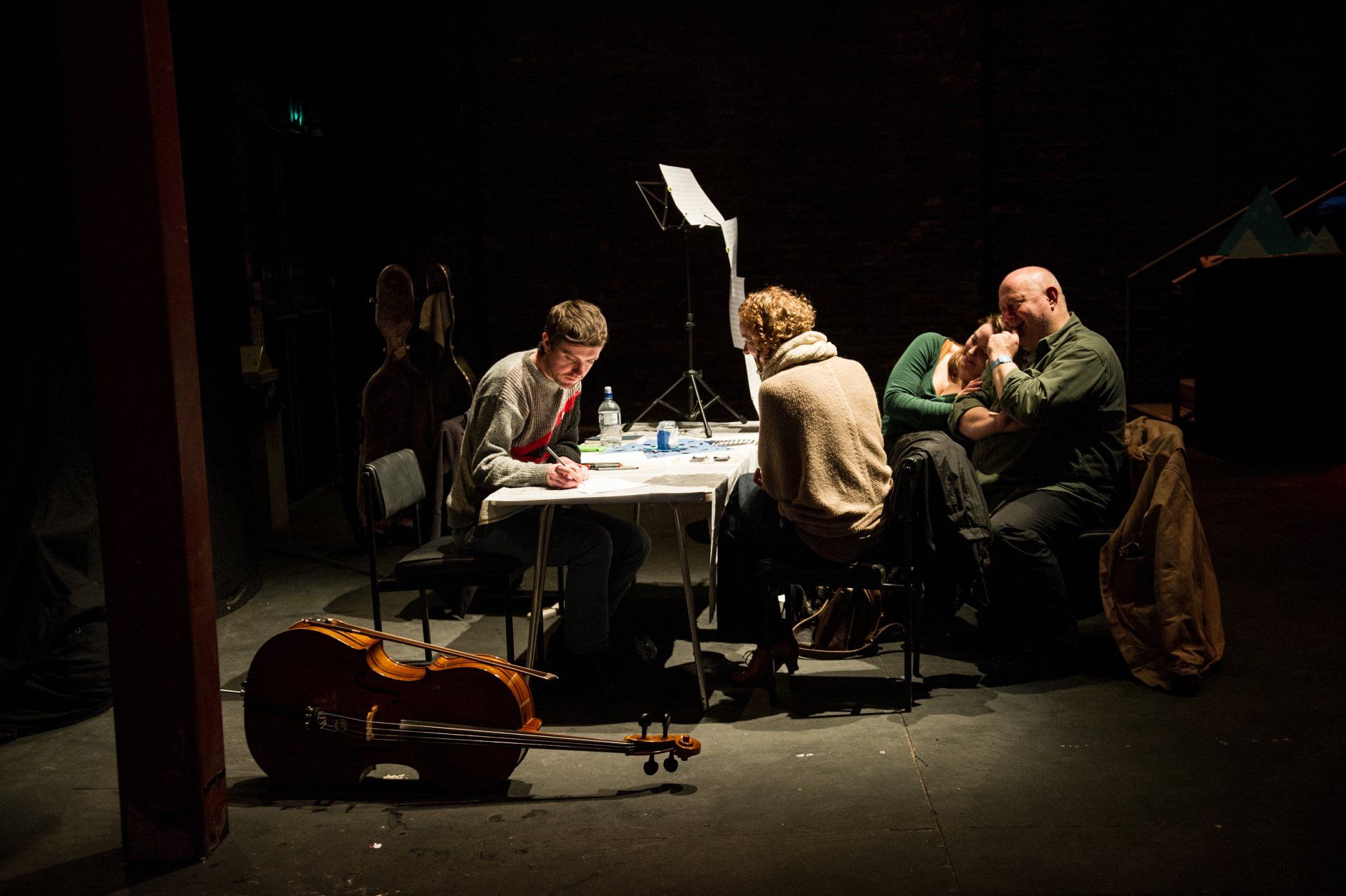 A group of people are sitting around a table in a dark room.