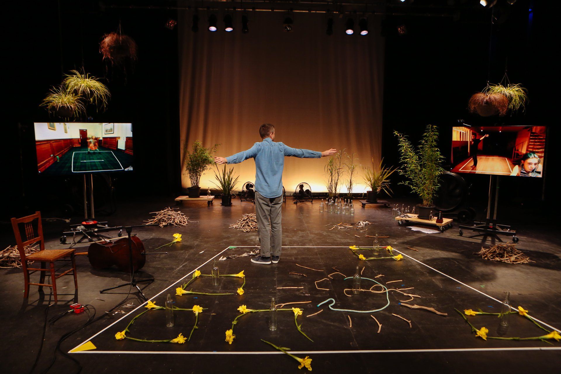 A man is standing on a stage with his arms outstretched.