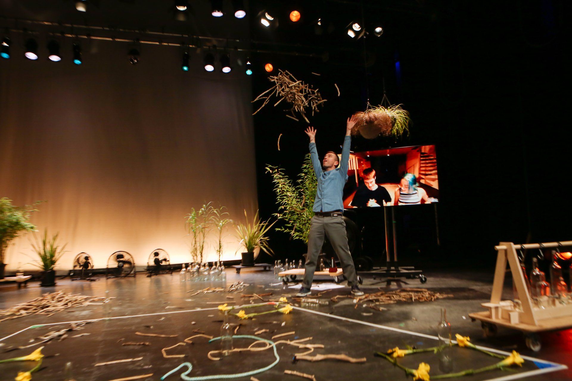 A man is standing on a stage with his arms in the air