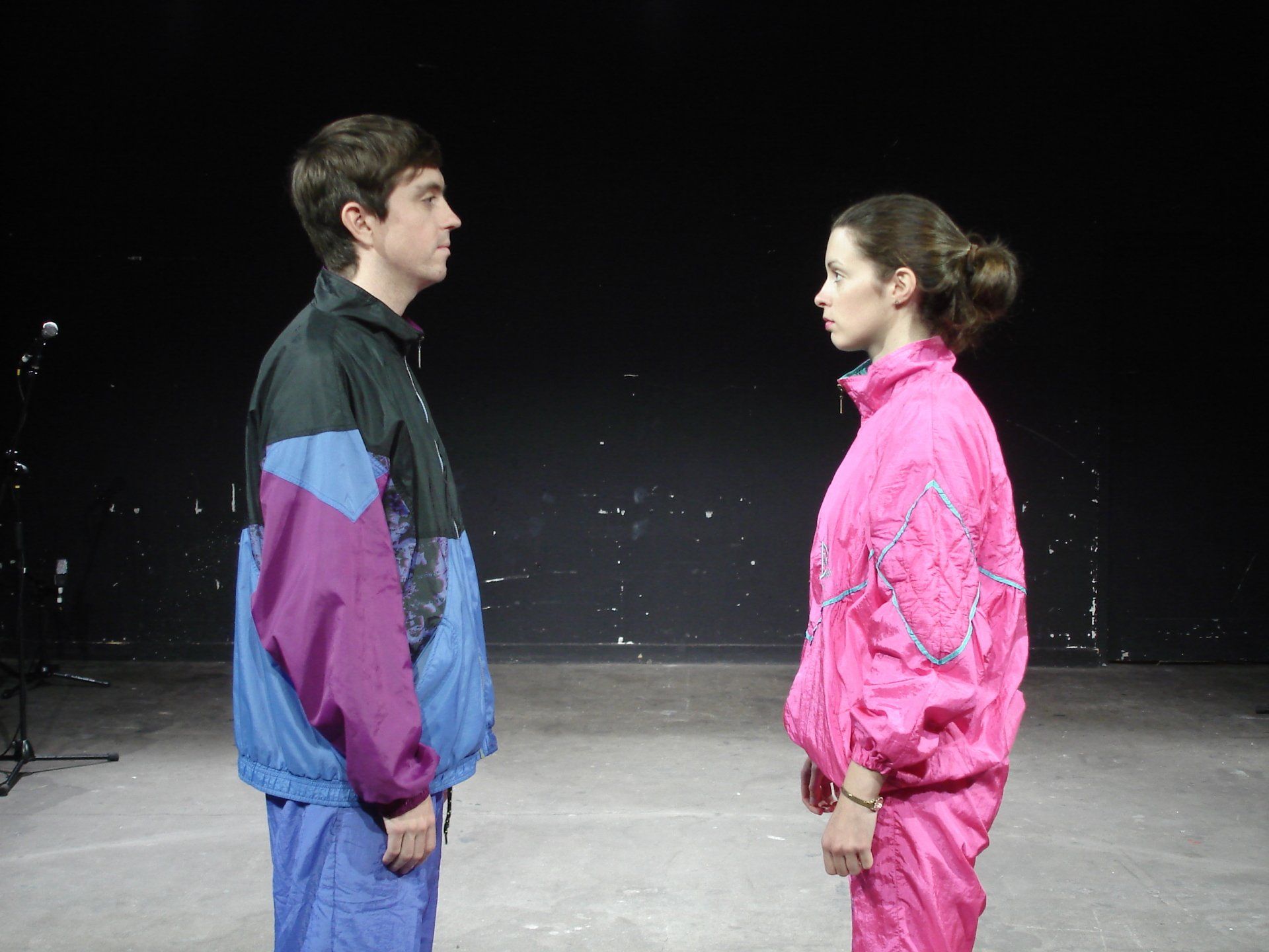A man and a woman are standing next to each other in a dark room.