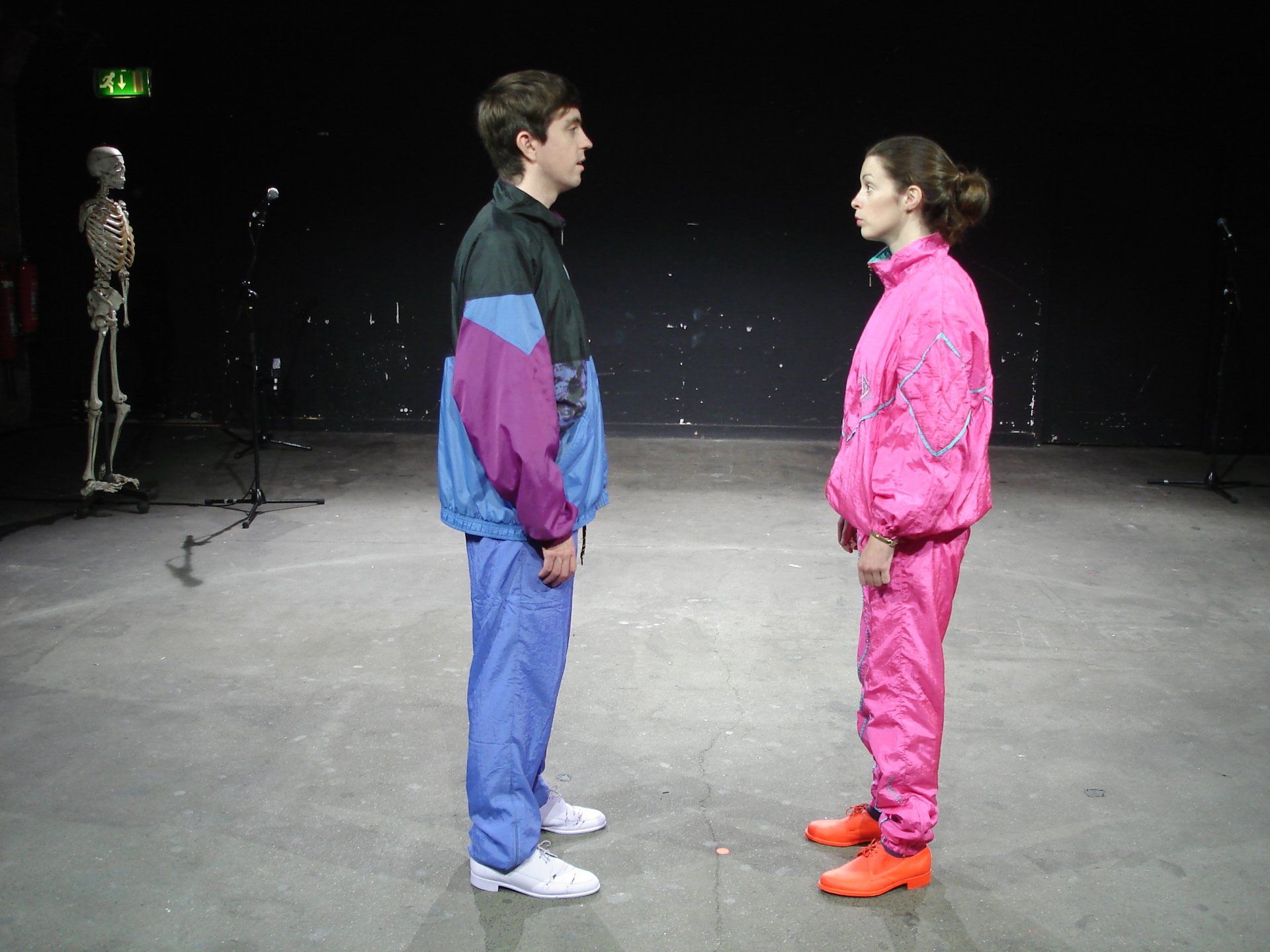 A man and a woman are standing next to each other in a dark room.