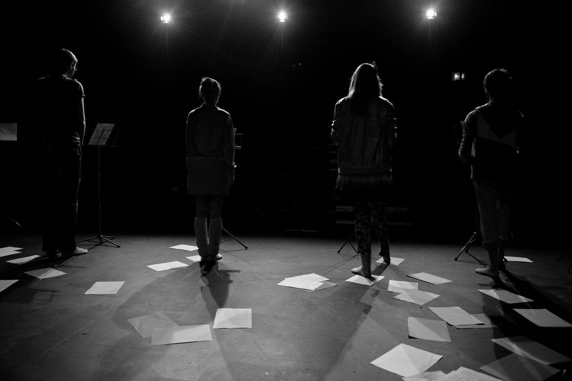 A group of people standing on a stage with papers on the floor