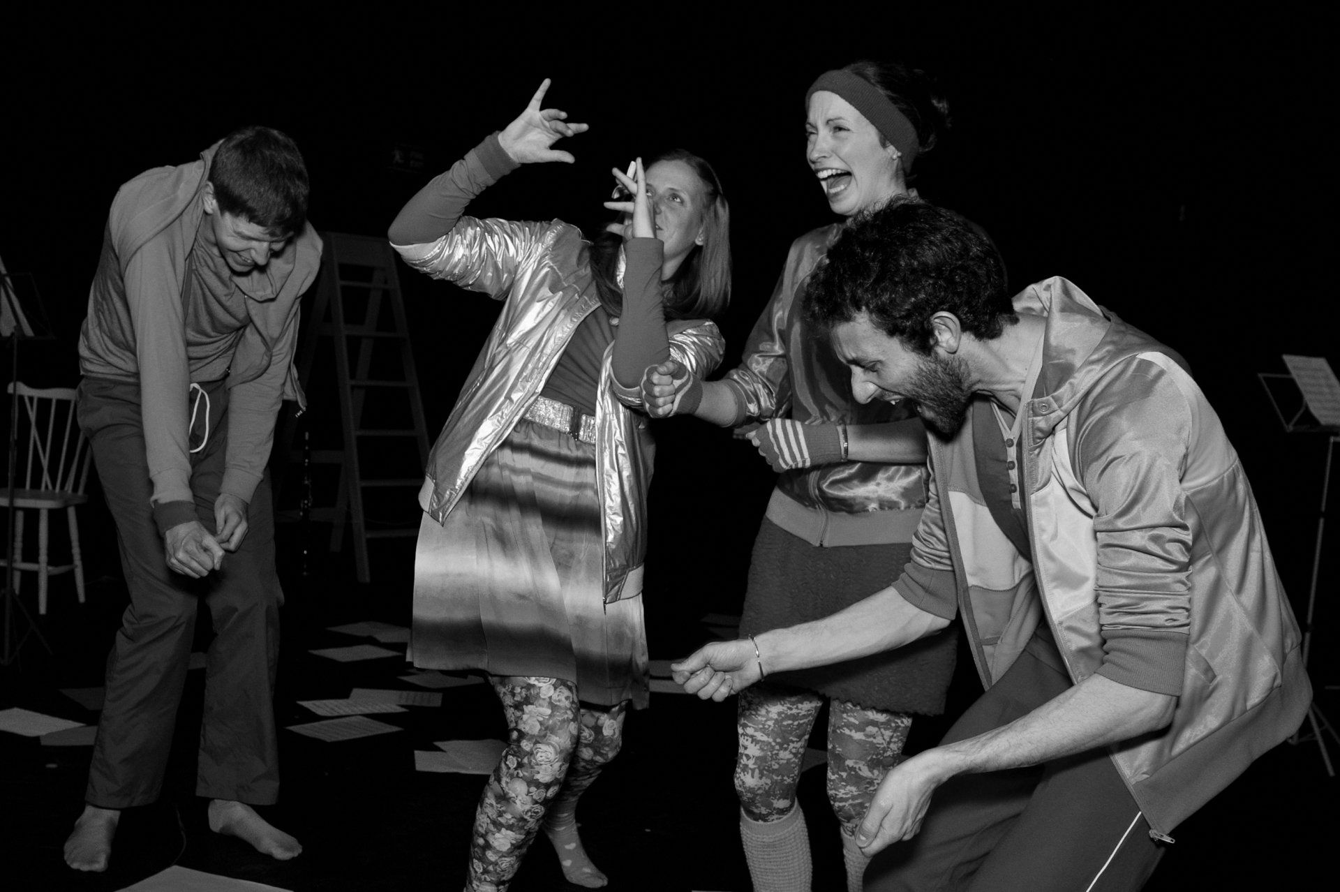 A group of people are dancing together in a black and white photo.