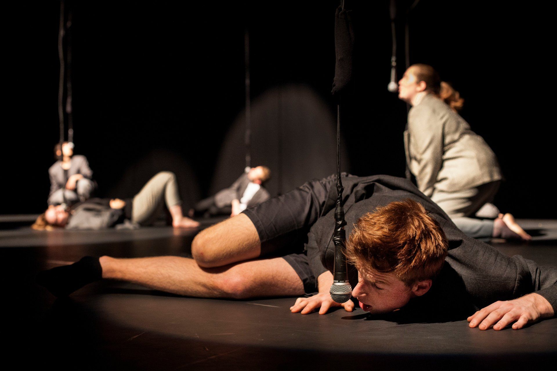 A group of people are laying on the floor on a stage.