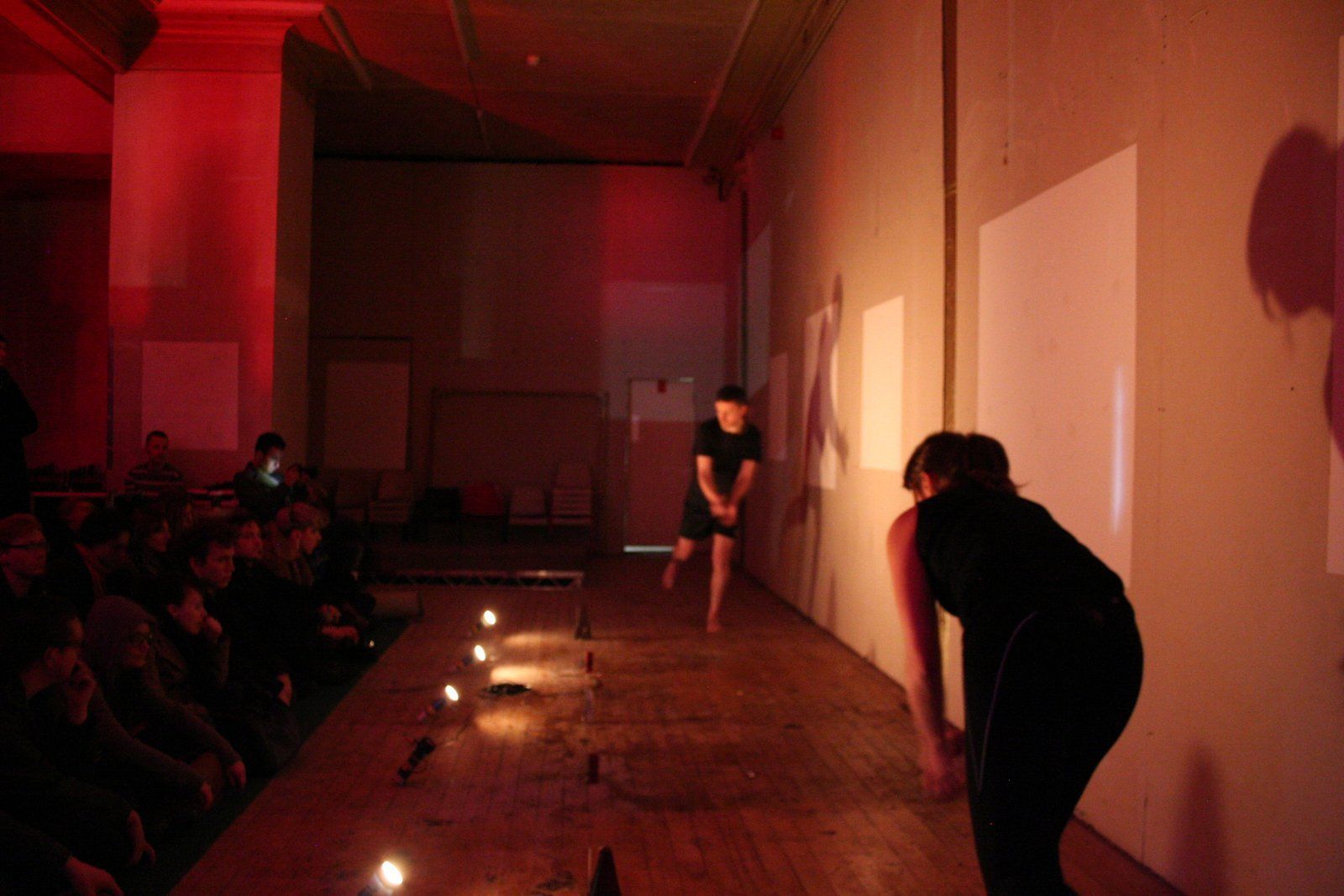 A couple of people are standing on a stage in a dark room.