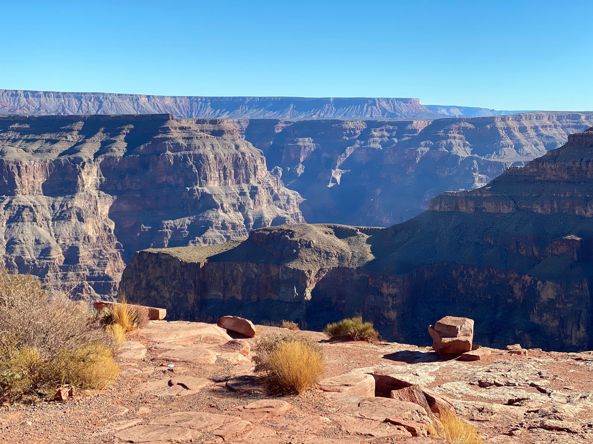A view of a canyon with a blue sky in the background