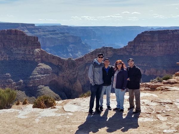 A group of people are posing for a picture in front of a canyon.