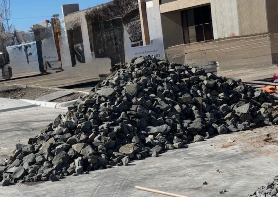 A pile of silvermist gravel is sitting next to a dump truck.