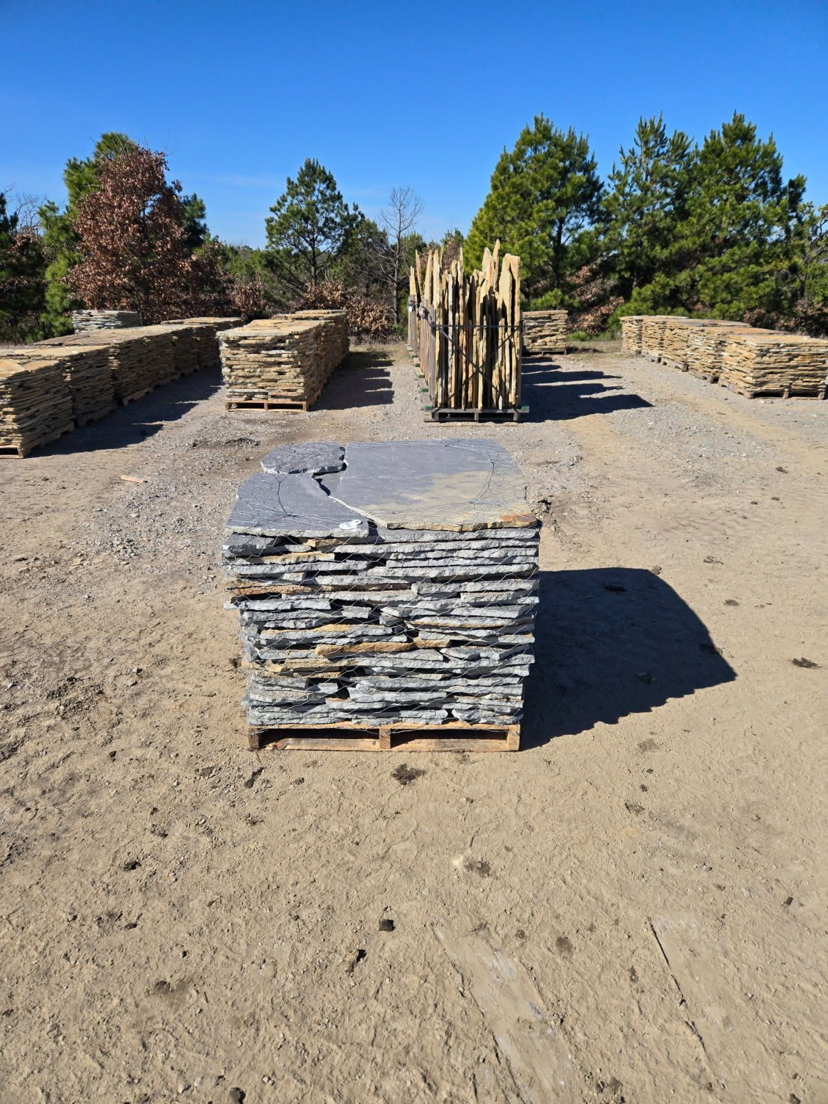 A wooden crate filled with white mountain boulders is sitting on the ground.