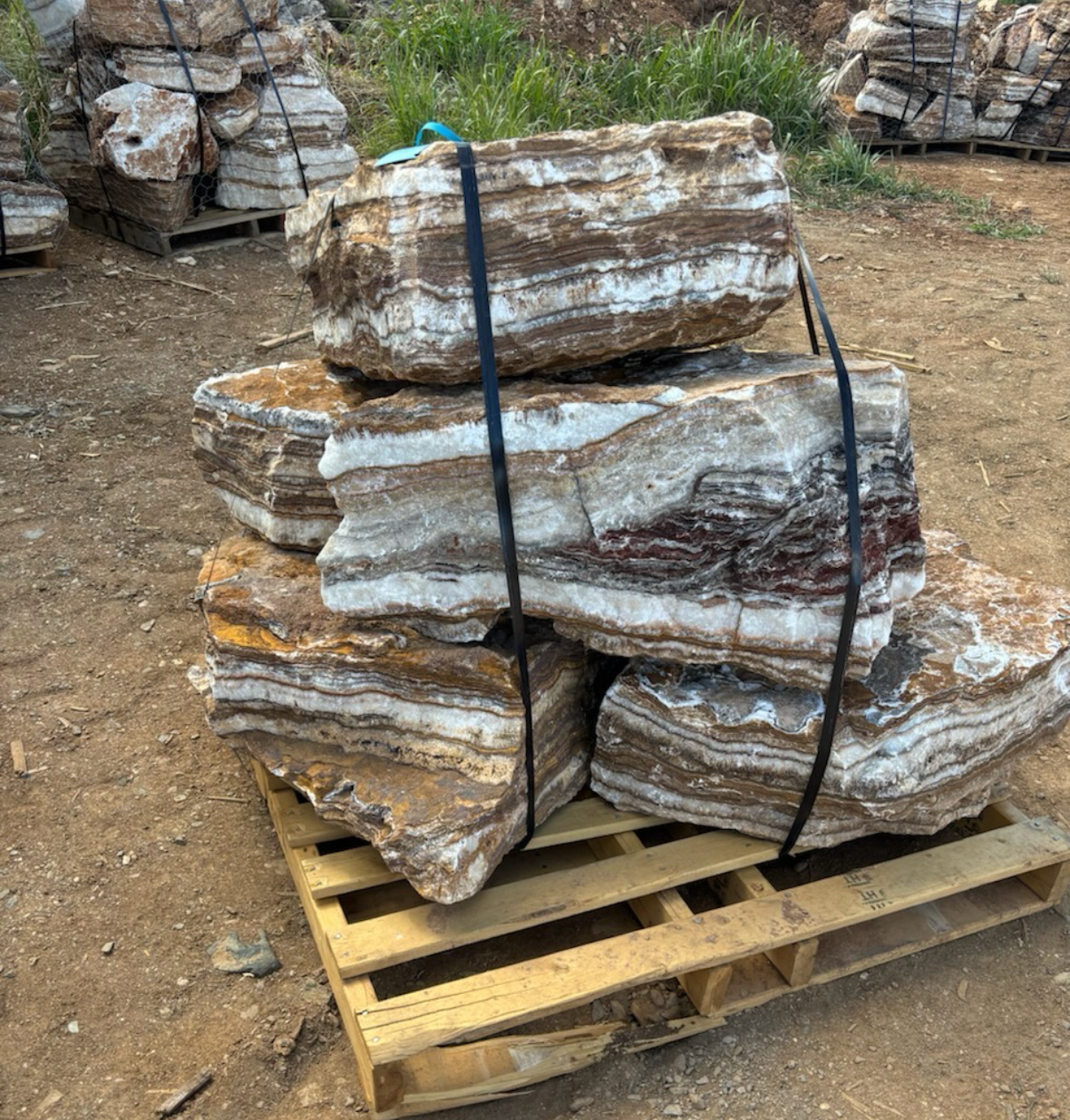 A wooden crate filled with large black rocks.