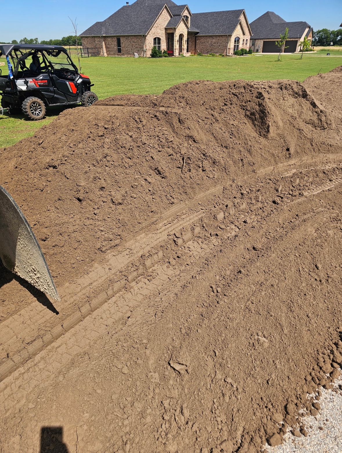 A pile of tan oklahoma flagstone sitting on top of each other on a dirt field.