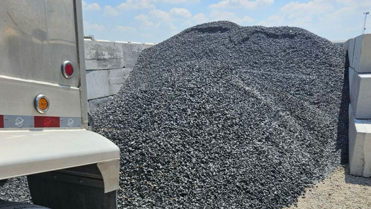 A pile of SIlver Mist gravel is sitting next to a truck.