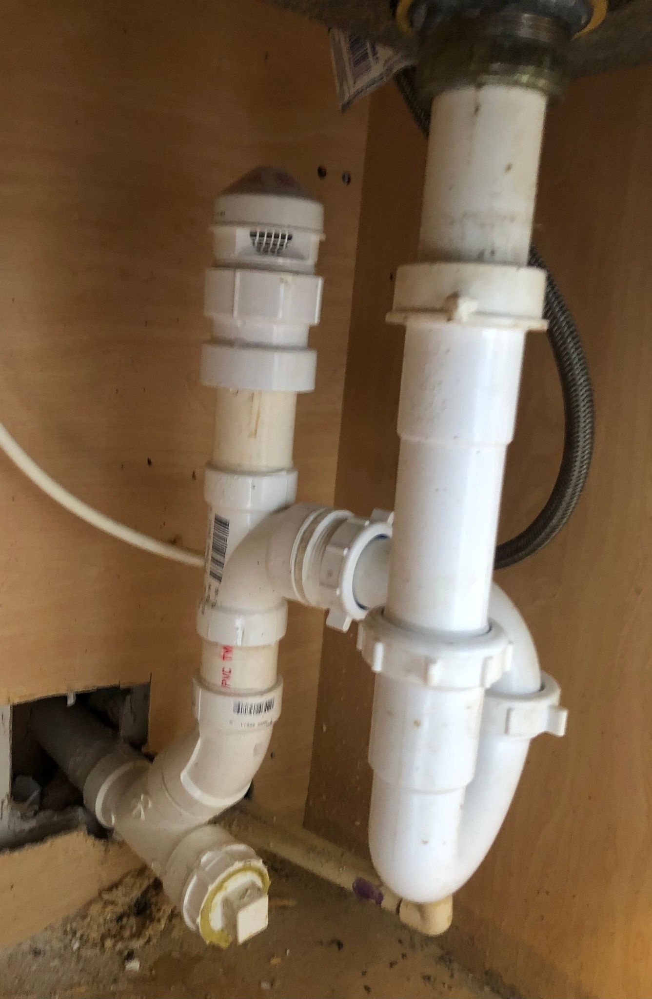 A close up of a sink drain pipe in a kitchen.