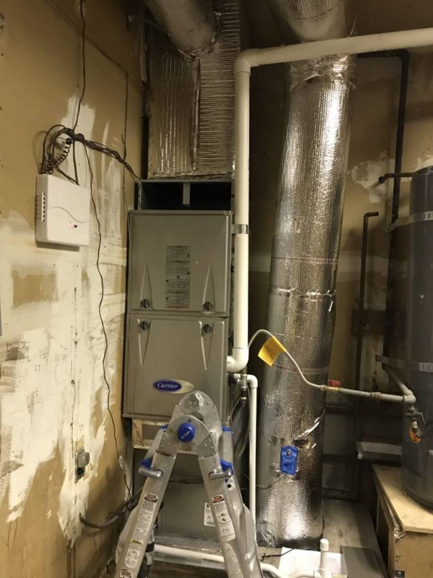 a ladder is sitting next to a furnace in a room .