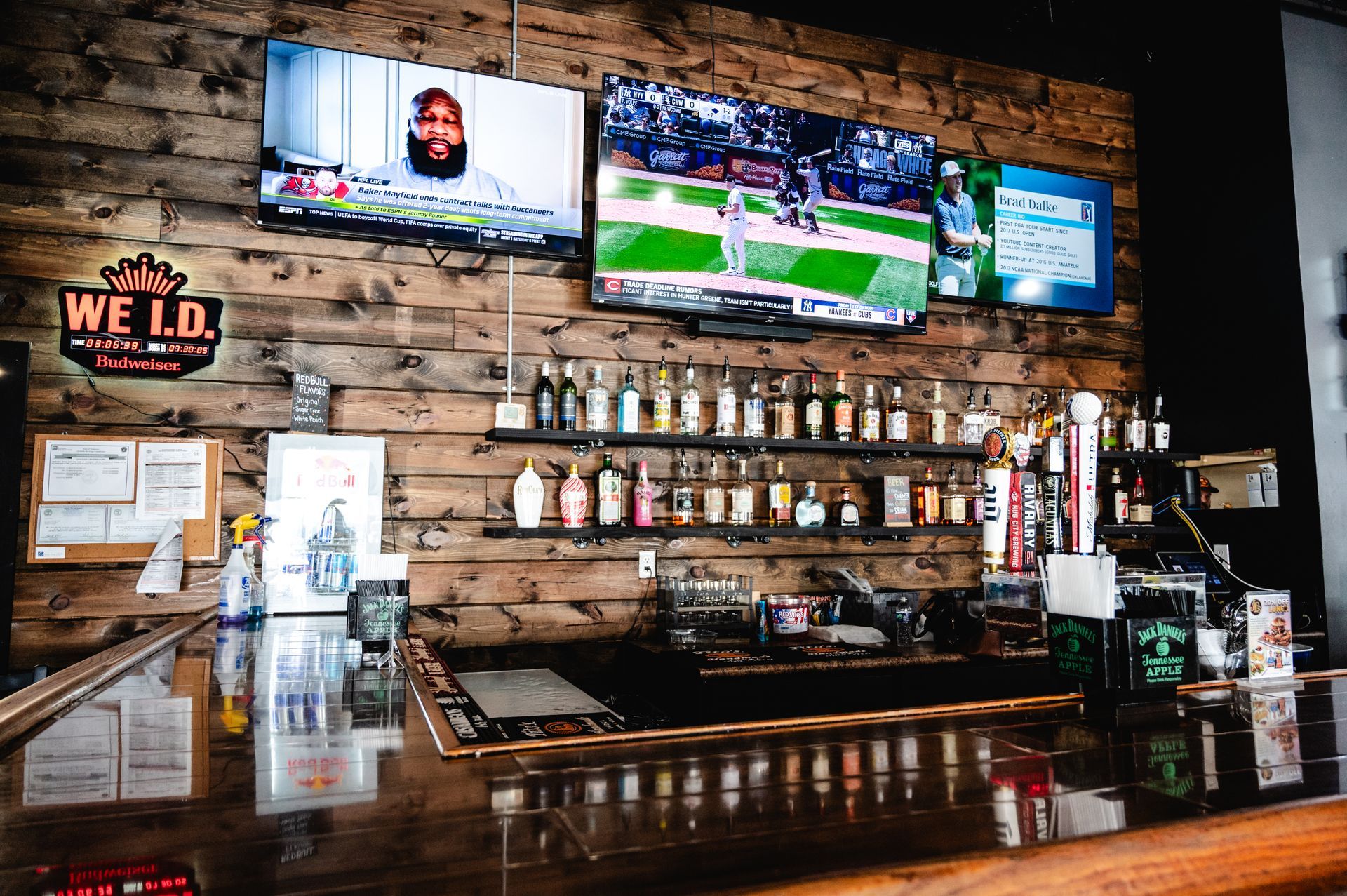 A bar with a large screen displaying a news report