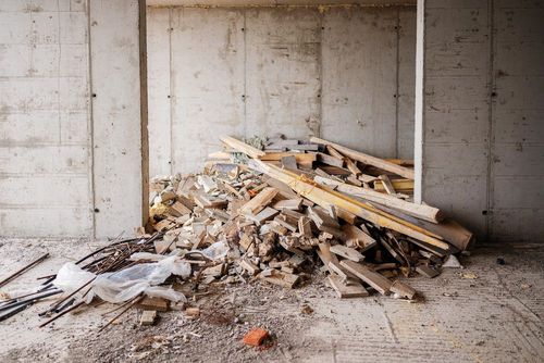 Pile of construction debris and broken wood in an unfinished concrete room