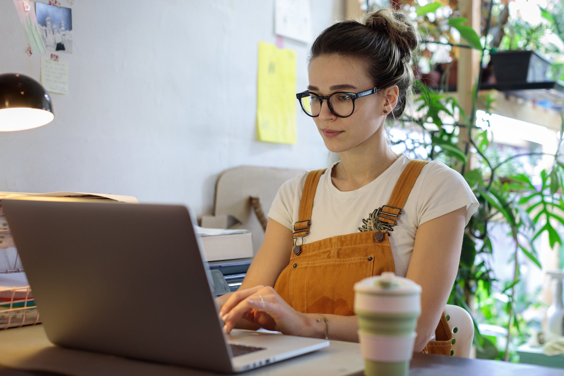 woman in glasses working on laptop, kink-friendly teletherapy for residents of MA