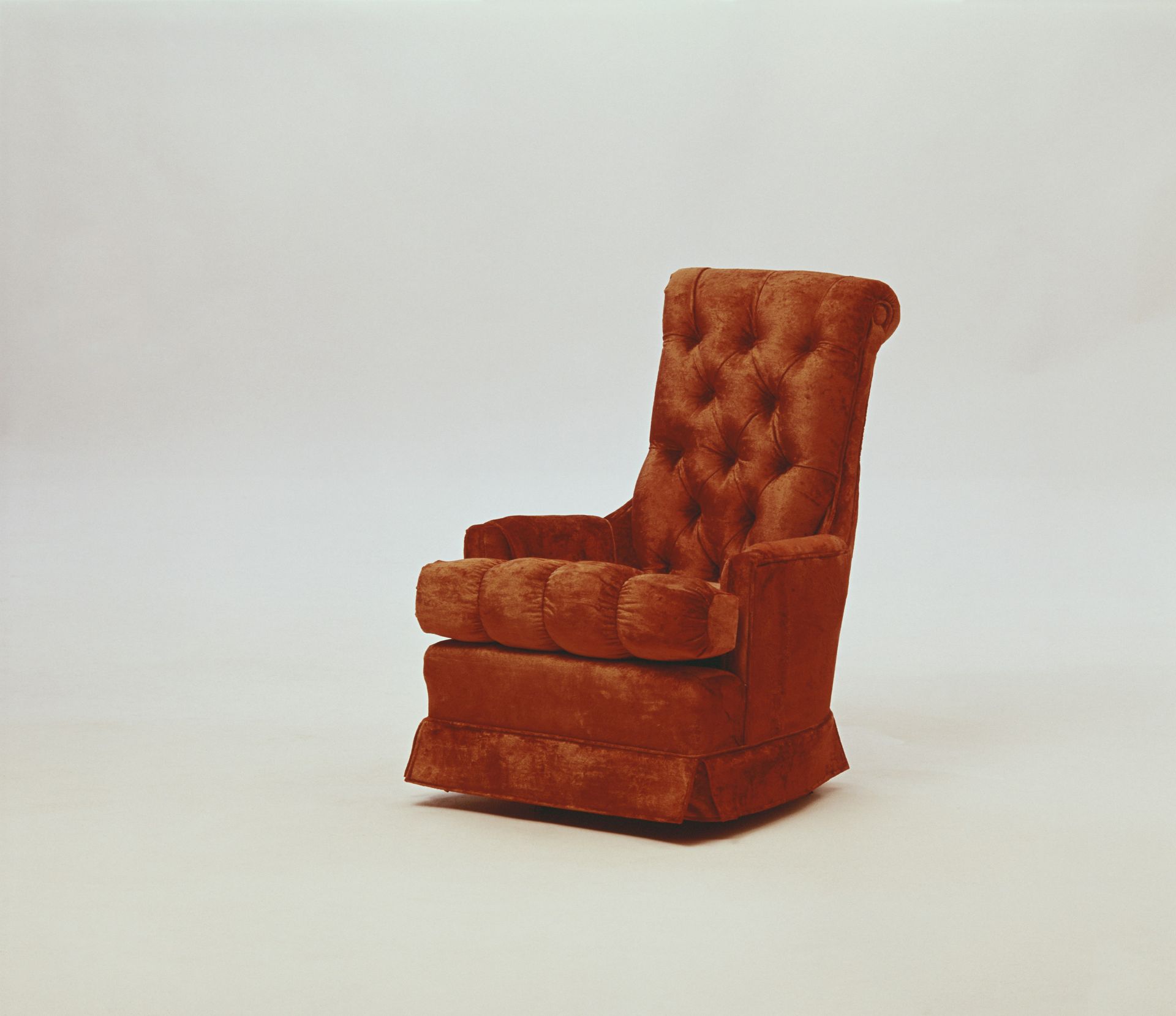 A rust colored armchair perfect for a therapist sits alone.