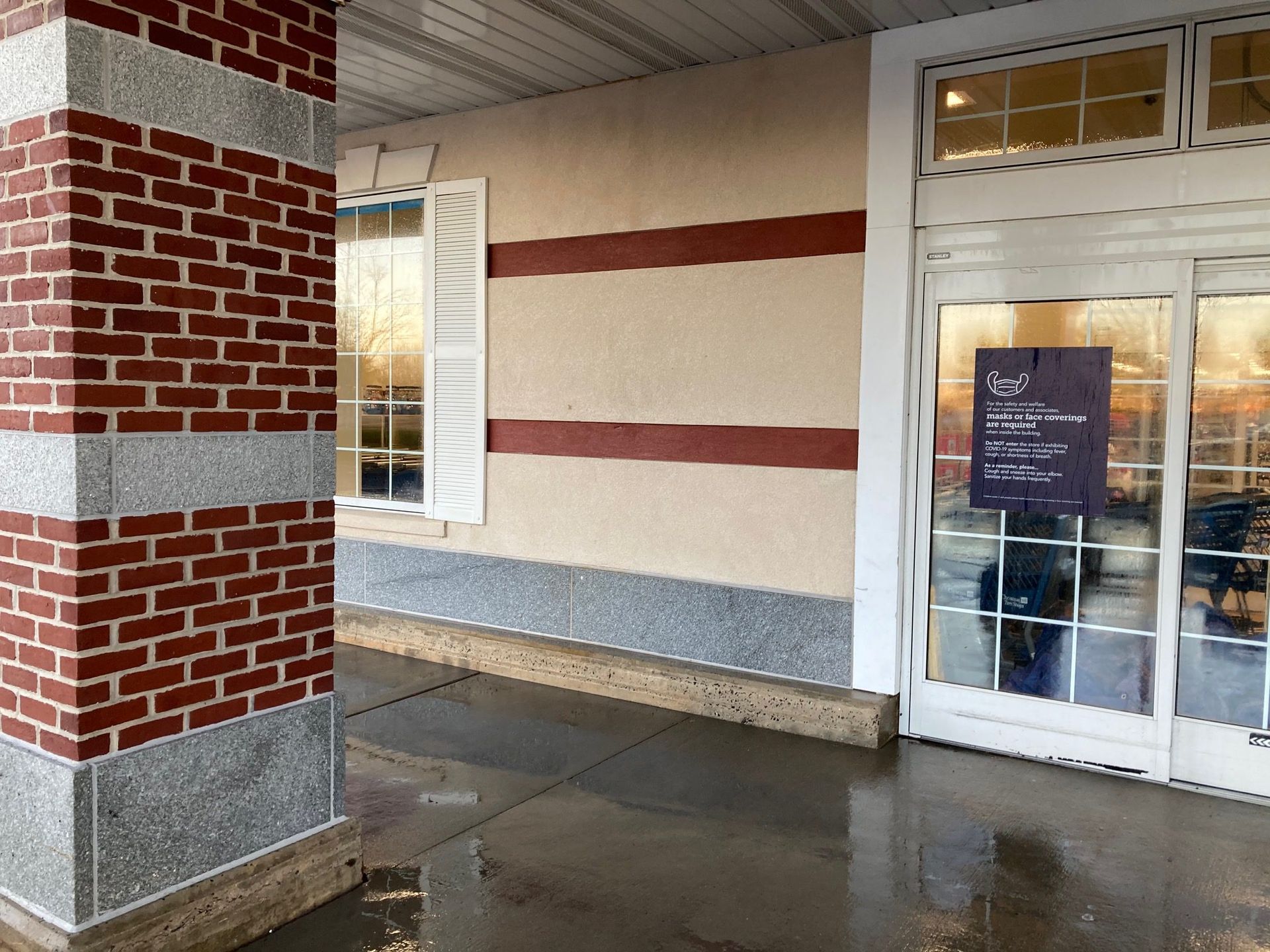 A brick building with a purple sign in front of it