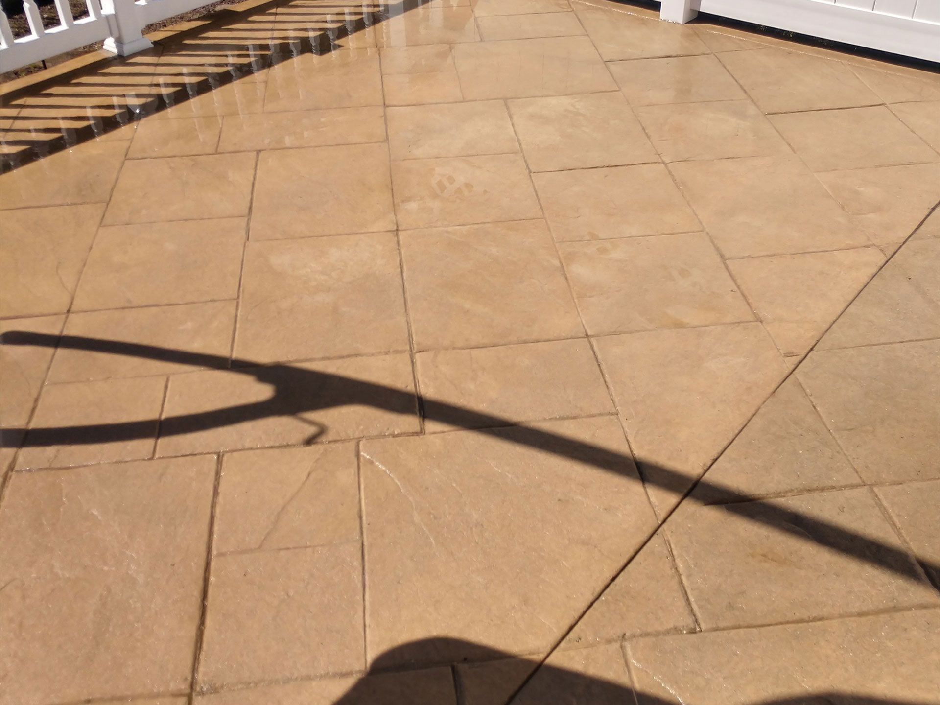 A shadow of a person is cast on a tiled floor