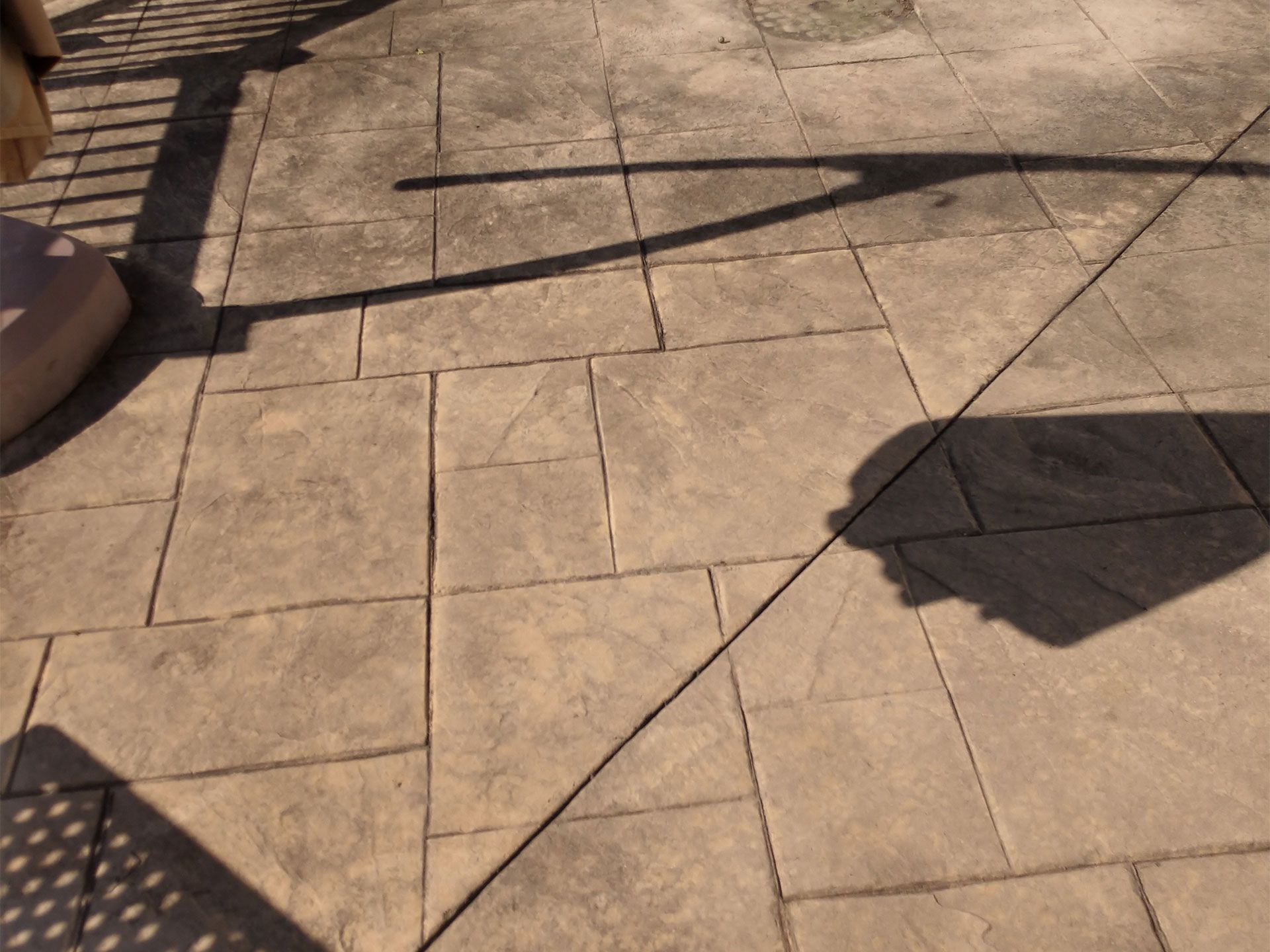 A shadow of a person is cast on a tiled floor