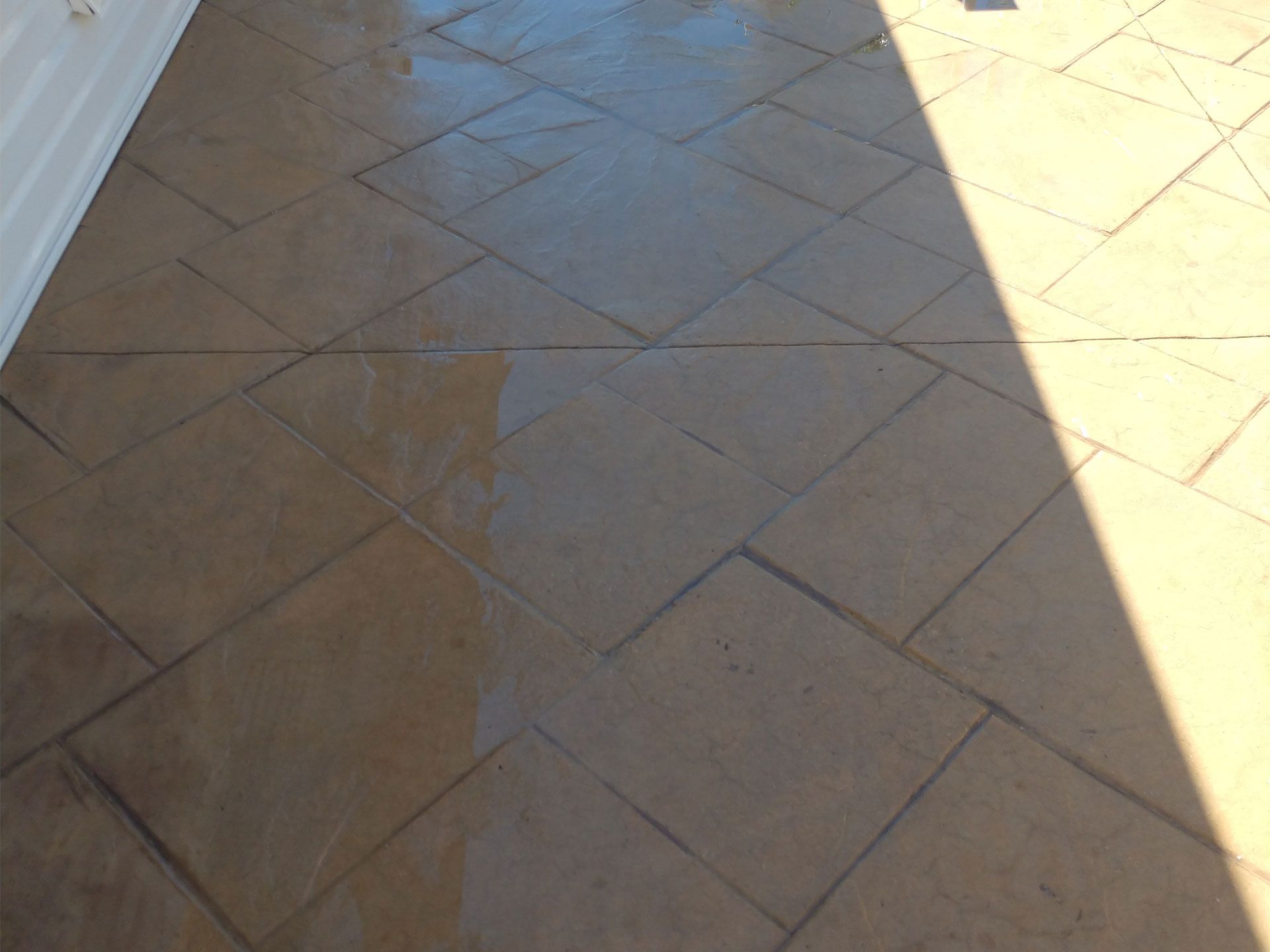 A shadow of a person is cast on a tiled floor
