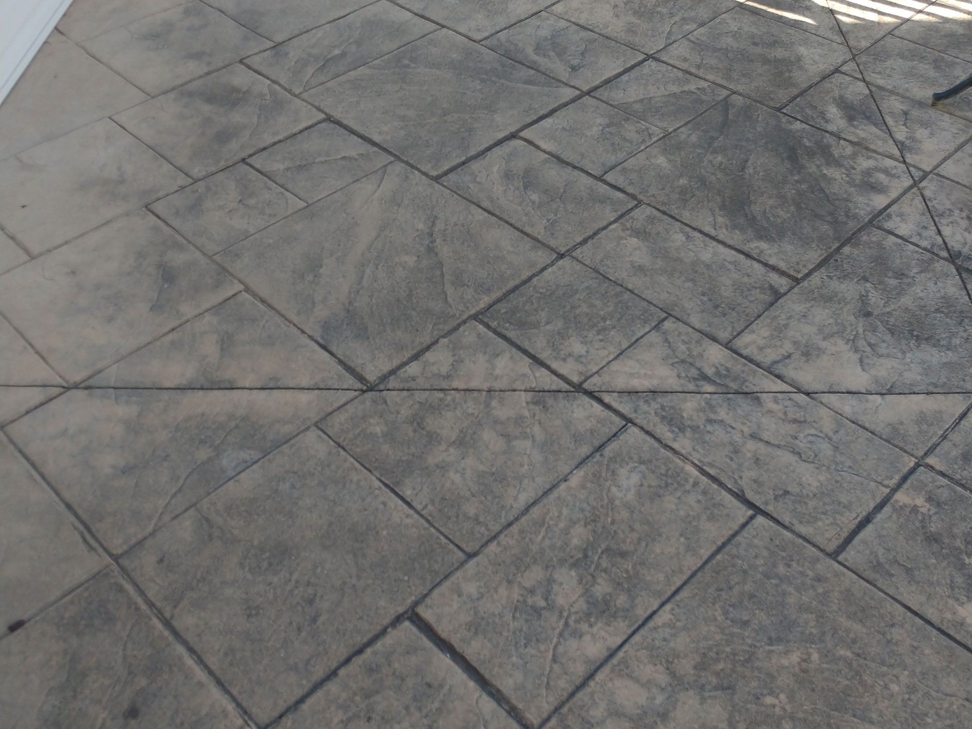 A concrete floor with a pattern of squares on it