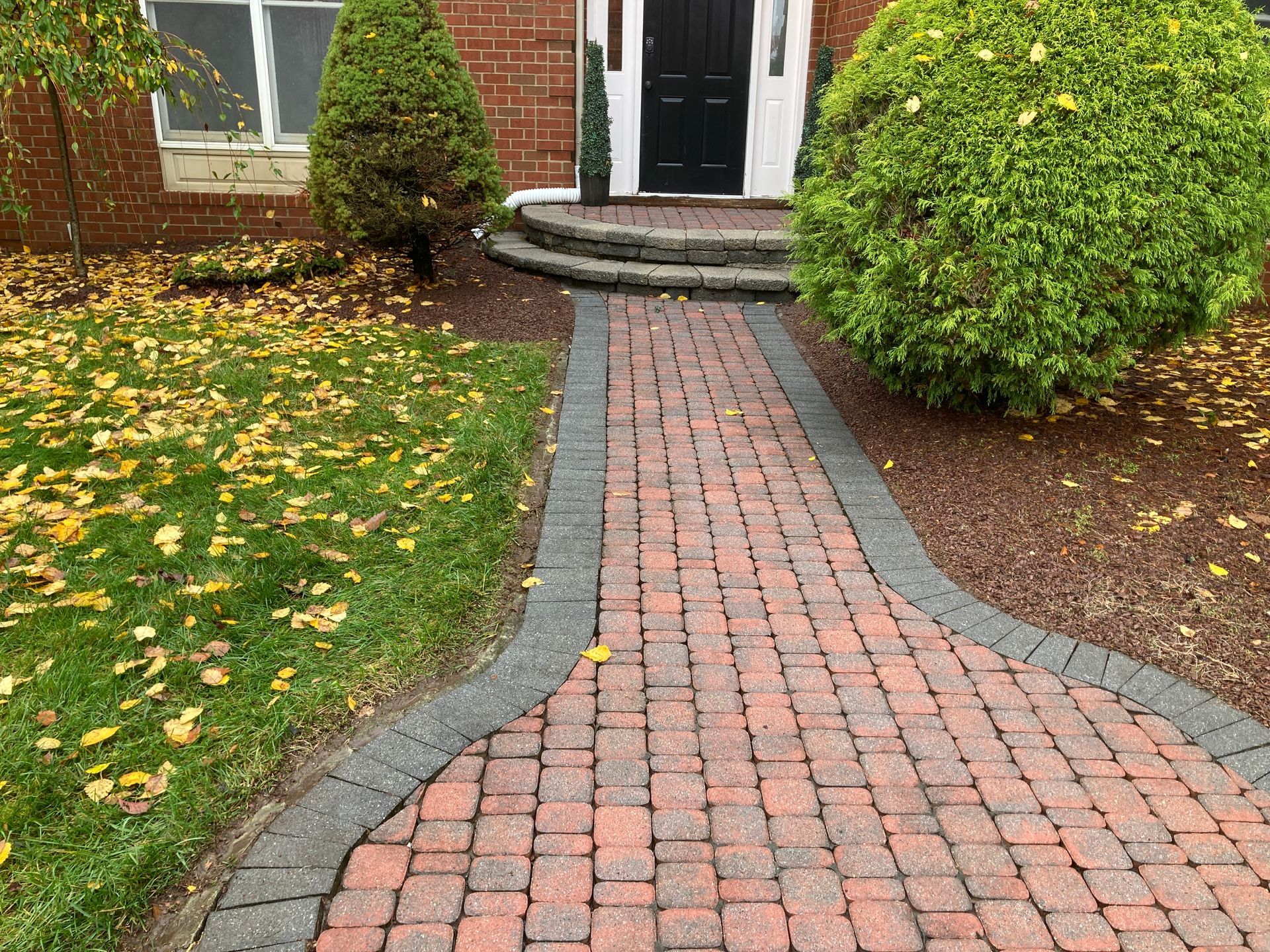 A brick walkway leading to the front door of a house.