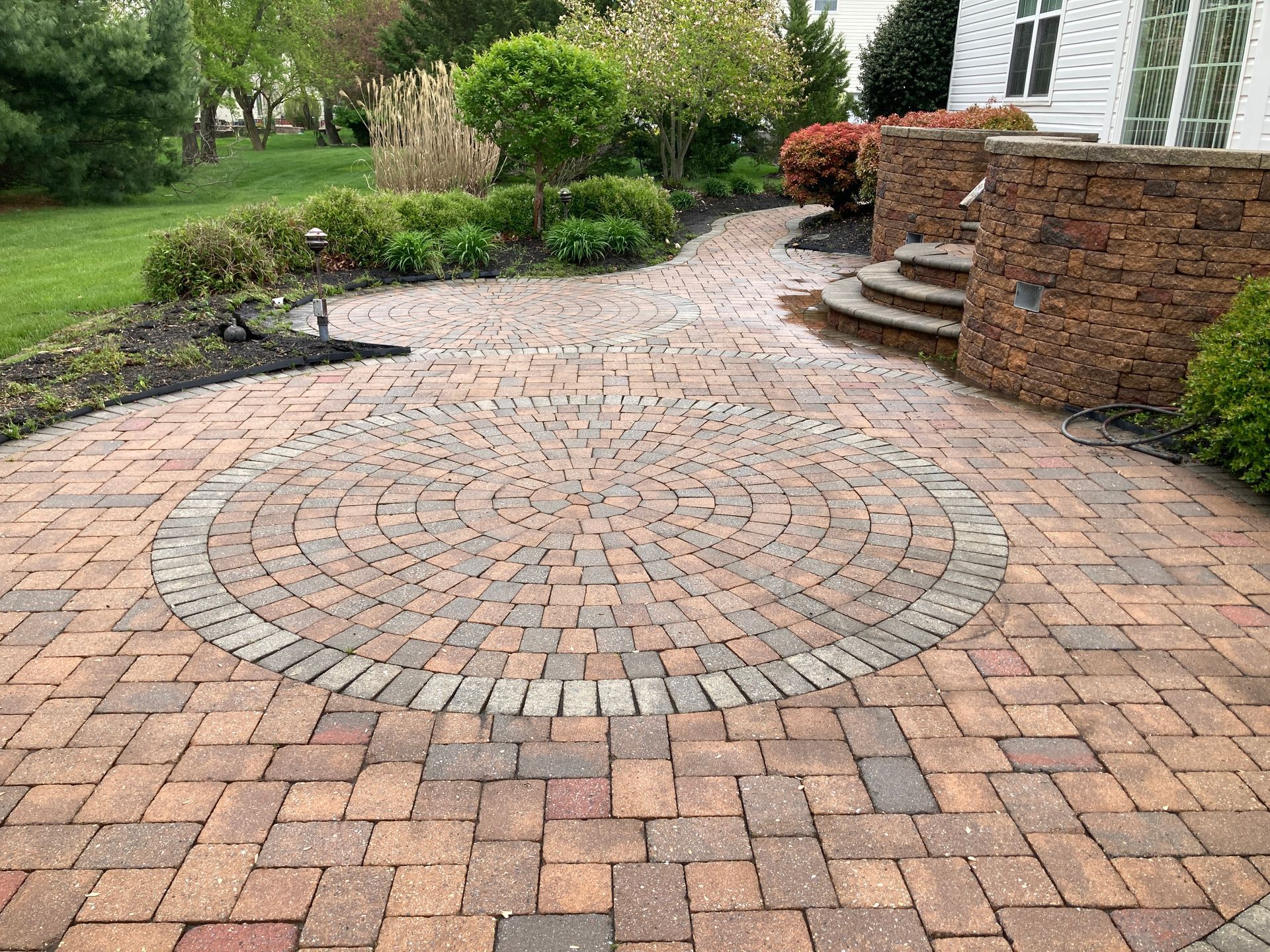 A brick patio with a circular design in the middle of it.
